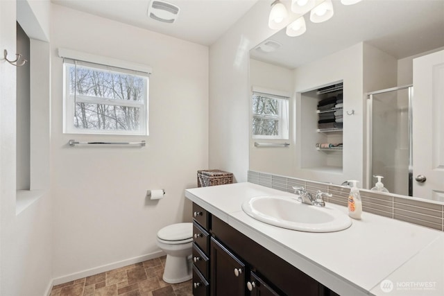 full bathroom featuring vanity, toilet, baseboards, a shower stall, and visible vents