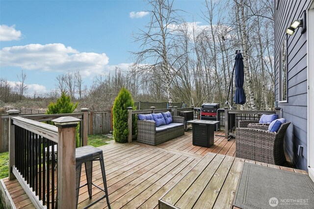 deck with an outdoor living space and fence