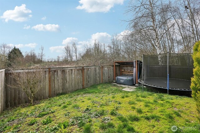 view of yard featuring a fenced backyard and a trampoline