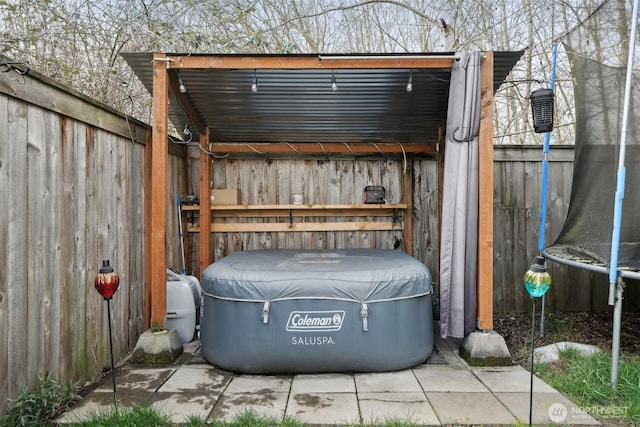 view of outbuilding featuring fence and a trampoline
