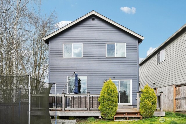 back of house featuring fence and a deck