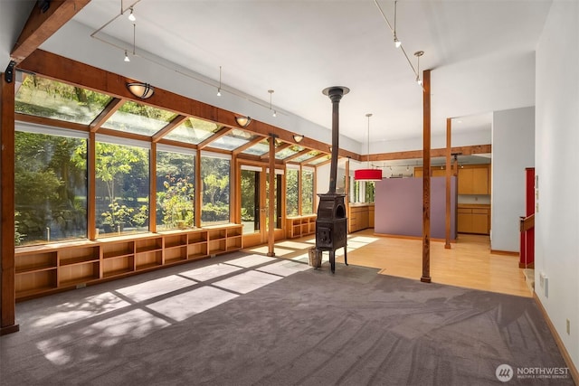 unfurnished sunroom with a wood stove