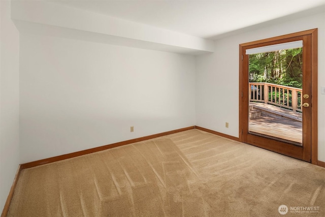 spare room featuring baseboards and light colored carpet