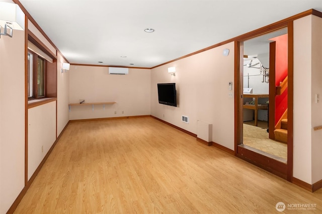 unfurnished living room featuring crown molding, light wood-style flooring, baseboards, visible vents, and stairway