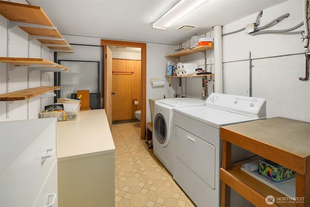 washroom with light floors, laundry area, and washing machine and clothes dryer