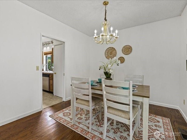3616 SW 325th St, Federal Way, WA 98023 - dining room with a chandelier, wood finished floors, a textured ceiling, and baseboards