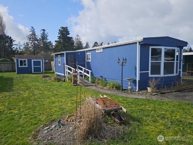 6505 Fawn Ln Unit 4, Long Beach, WA 98631 - view of front of home featuring an outdoor structure, a front yard, and a shed