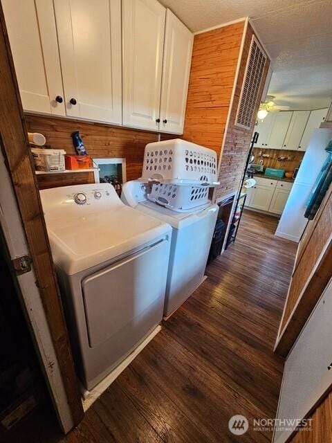 6505 Fawn Ln Unit 4, Long Beach, WA 98631 - laundry area with wooden walls, ceiling fan, dark wood-type flooring, cabinet space, and washer and clothes dryer
