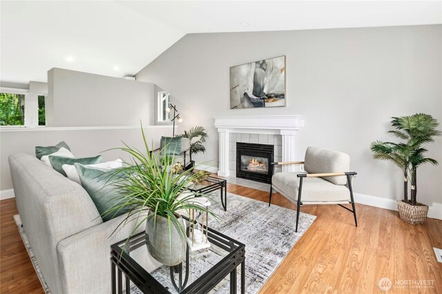 17406 Redhawk Dr, Arlington, WA 98223 - living room with a tile fireplace, lofted ceiling, wood finished floors, and baseboards