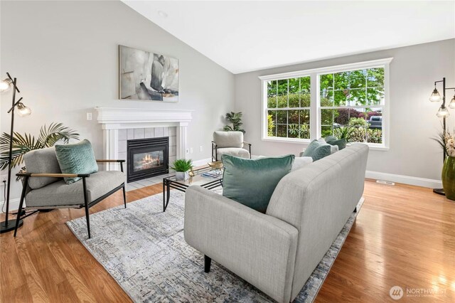 17406 Redhawk Dr, Arlington, WA 98223 - living room with a fireplace, baseboards, vaulted ceiling, and wood finished floors