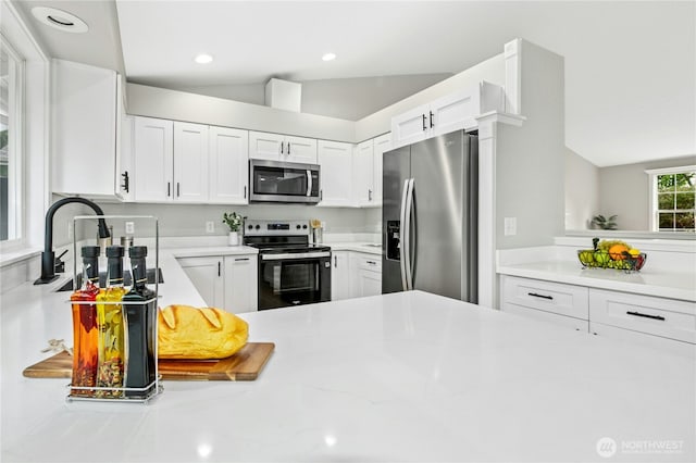 17406 Redhawk Dr, Arlington, WA 98223 - kitchen featuring appliances with stainless steel finishes, white cabinetry, a sink, recessed lighting, and light stone counters