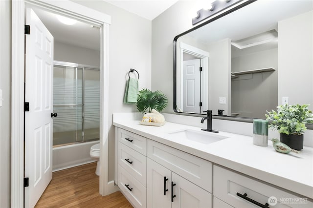 17406 Redhawk Dr, Arlington, WA 98223 - full bath featuring vanity, toilet, wood finished floors, and enclosed tub / shower combo