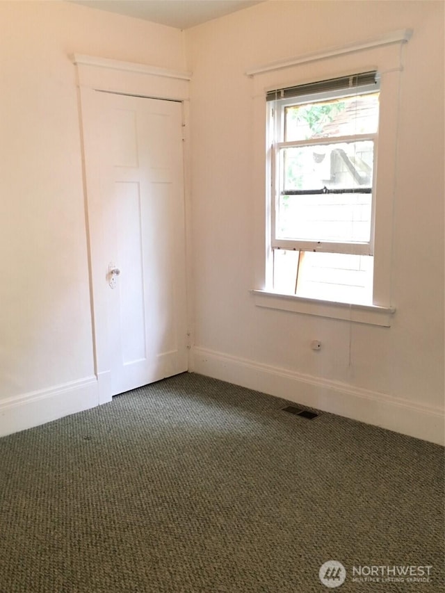 5011 8th Ave NE, Seattle, WA 98105 - unfurnished bedroom with baseboards, visible vents, and carpet floors
