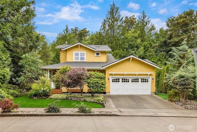 view of front facade with a garage, concrete driveway, and a front lawn