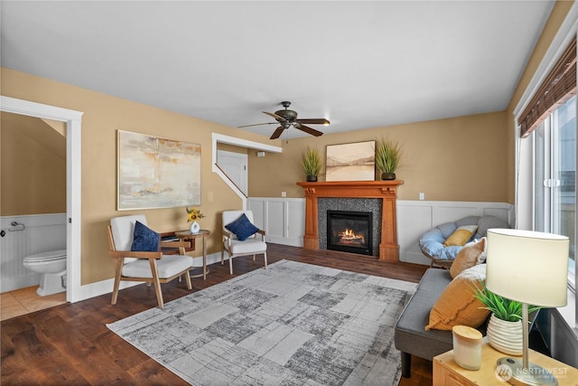 1625 185th Street Ct E, Spanaway, WA 98387 - living area with a wainscoted wall, a glass covered fireplace, wood finished floors, and ceiling fan