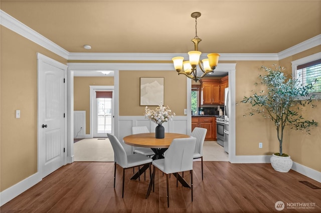 1625 185th Street Ct E, Spanaway, WA 98387 - dining space with a chandelier, wood finished floors, and ornamental molding