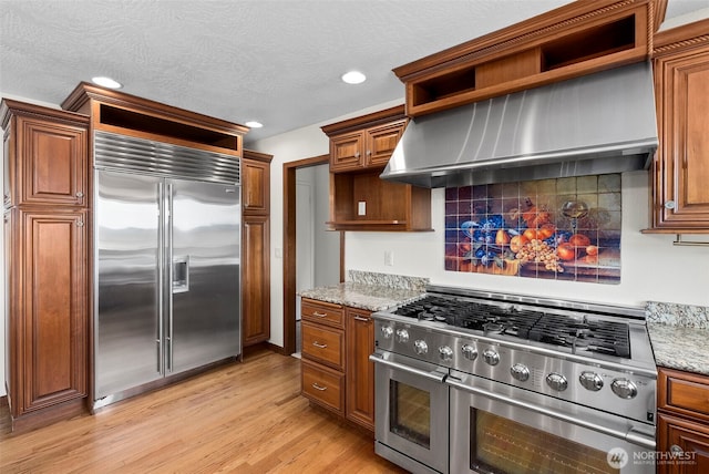 1918 SE Maple Dr, Chehalis, WA 98532 - kitchen with premium appliances, light wood-type flooring, brown cabinetry, open shelves, and decorative backsplash