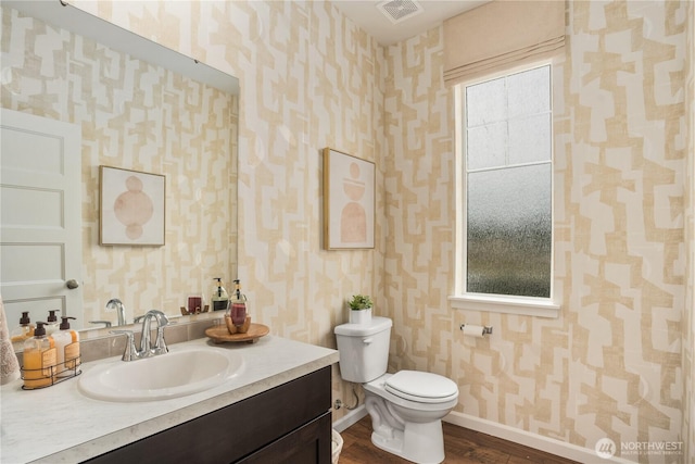 1133 68th Ave SE, Tumwater, WA 98501 - bathroom with visible vents, toilet, wood finished floors, wallpapered walls, and baseboards