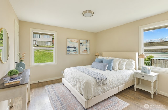 bedroom with baseboards and wood finished floors