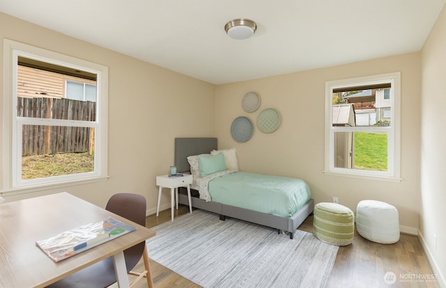 bedroom featuring baseboards and wood finished floors