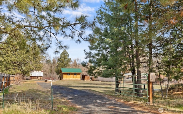 view of front of home featuring a gate, an outdoor structure, and fence