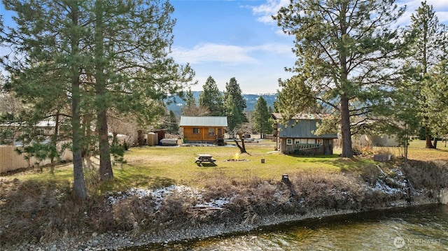 view of yard featuring an outbuilding, an outdoor fire pit, and fence
