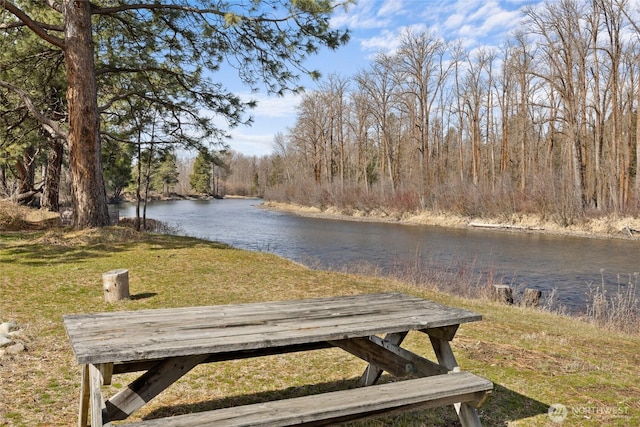 surrounding community with a yard, a water view, and a wooded view