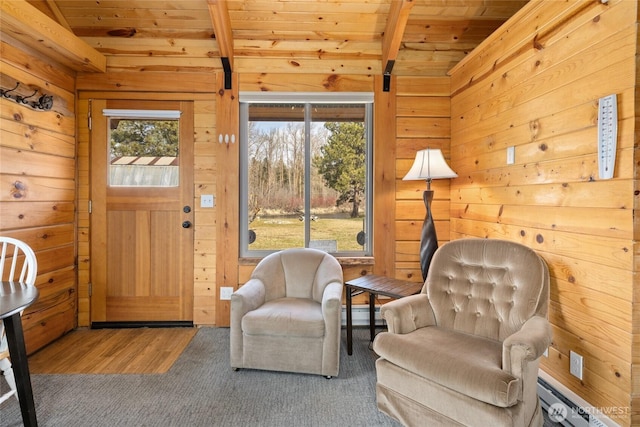 living area with wood walls, wood ceiling, beam ceiling, baseboard heating, and wood finished floors