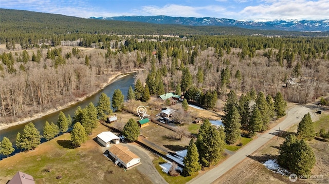 bird's eye view featuring a forest view and a water and mountain view