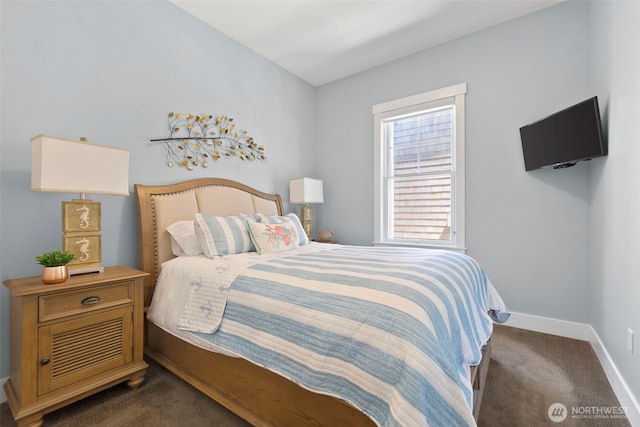 bedroom featuring dark colored carpet and baseboards