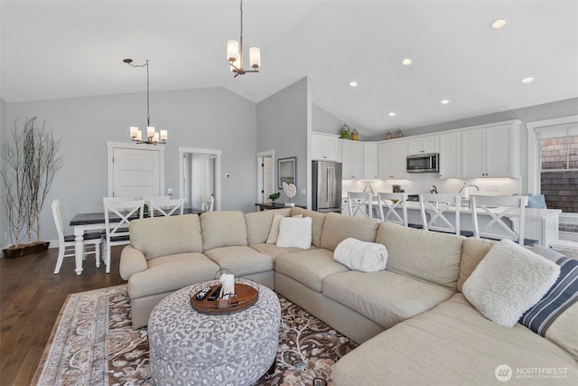 living area featuring recessed lighting, dark wood-type flooring, an inviting chandelier, and high vaulted ceiling