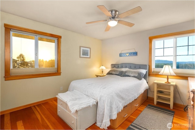 bedroom featuring wood finished floors, baseboards, and ceiling fan