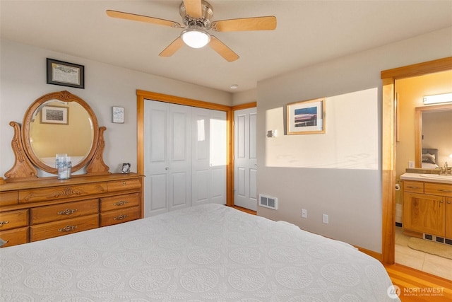 bedroom with visible vents, a ceiling fan, ensuite bathroom, and a sink