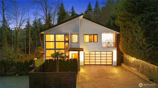 view of front facade with decorative driveway, stucco siding, and an attached garage