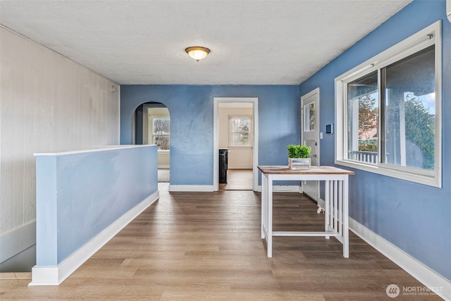 160 Maple St, Cathlamet, WA 98612 - corridor with arched walkways, a textured ceiling, baseboards, and wood finished floors