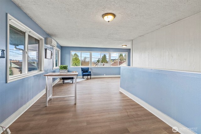160 Maple St, Cathlamet, WA 98612 - hallway with a textured ceiling, a wall mounted air conditioner, baseboards, and wood finished floors