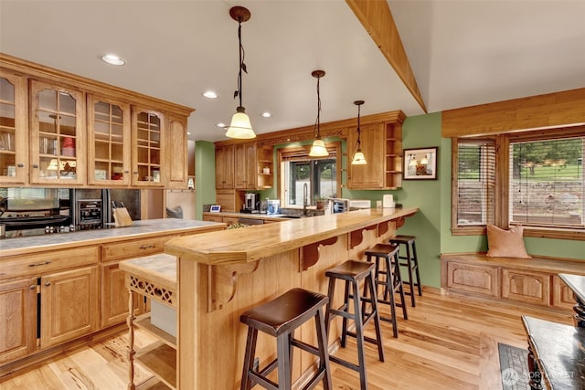 21401 161st Ave E, Graham, WA 98338 - kitchen with light wood finished floors, glass insert cabinets, a breakfast bar area, a peninsula, and open shelves