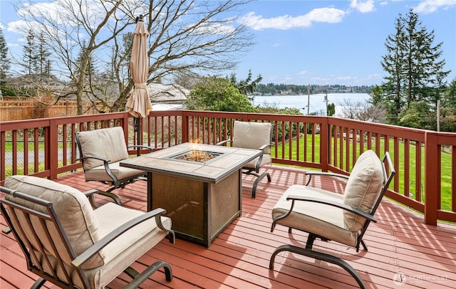wooden terrace with a water view and an outdoor fire pit