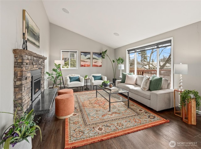 living area featuring a fireplace, lofted ceiling, and wood finished floors