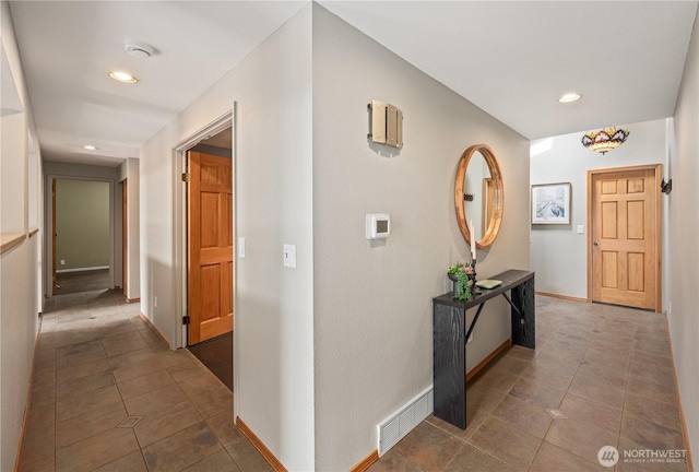 hallway featuring tile patterned floors, visible vents, baseboards, and recessed lighting