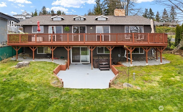 rear view of house with a patio, a yard, roof with shingles, a wooden deck, and a chimney