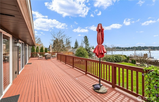 deck with a yard and a water view