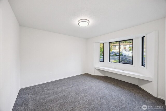 10231 Kiwa Dr SE, Olympia, WA 98513 - empty room featuring baseboards and dark carpet