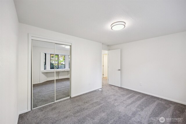 10231 Kiwa Dr SE, Olympia, WA 98513 - unfurnished bedroom with a closet, a textured ceiling, baseboards, and carpet floors