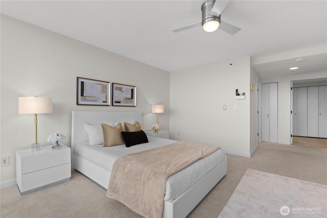 bedroom featuring a ceiling fan, baseboards, and light colored carpet
