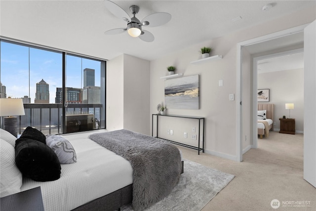 carpeted bedroom with baseboards, a ceiling fan, and a city view