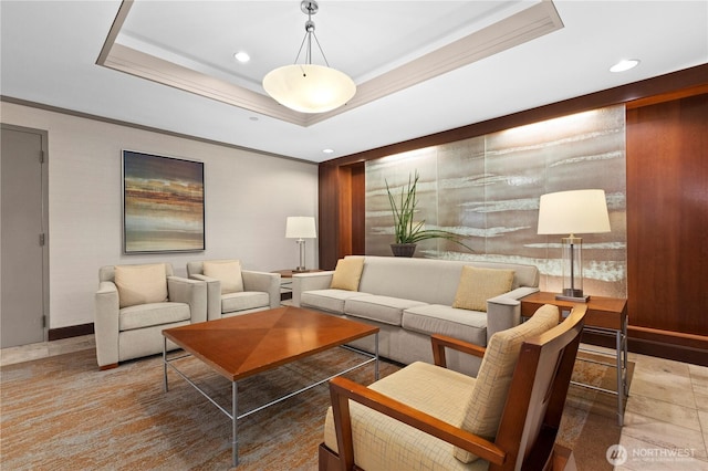 living area with a tray ceiling, recessed lighting, and crown molding