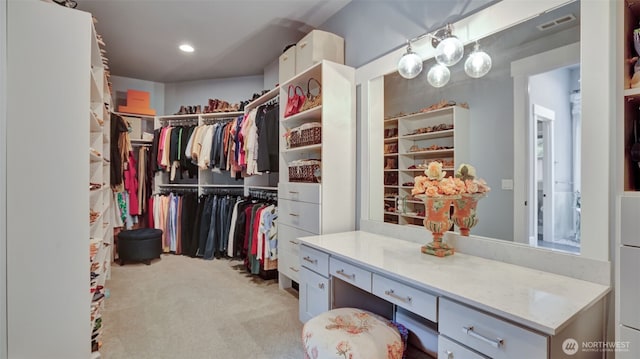 walk in closet with visible vents and light colored carpet