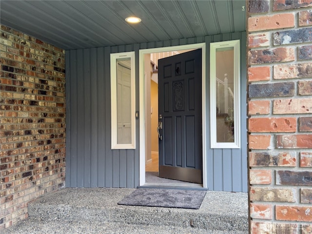 doorway to property with brick siding and board and batten siding