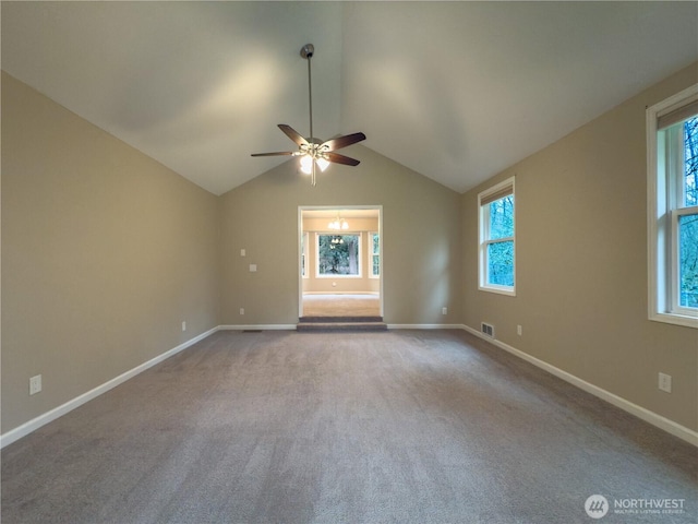 spare room with vaulted ceiling, baseboards, carpet floors, visible vents, and ceiling fan